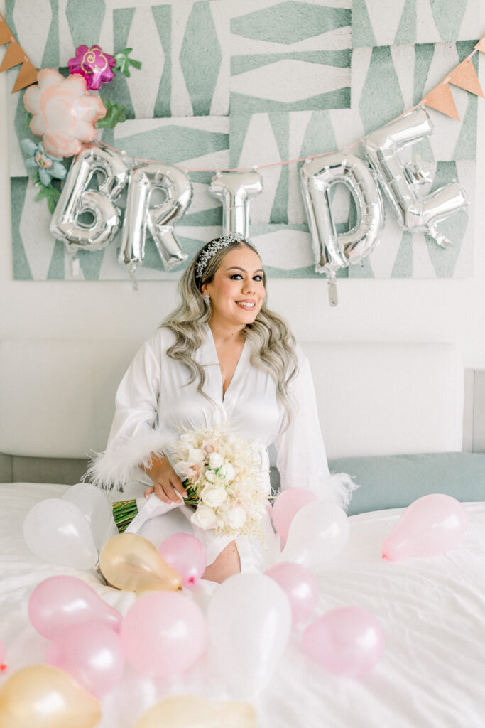 Bride at bedroom in la concha resort with robe and balloons and flowers