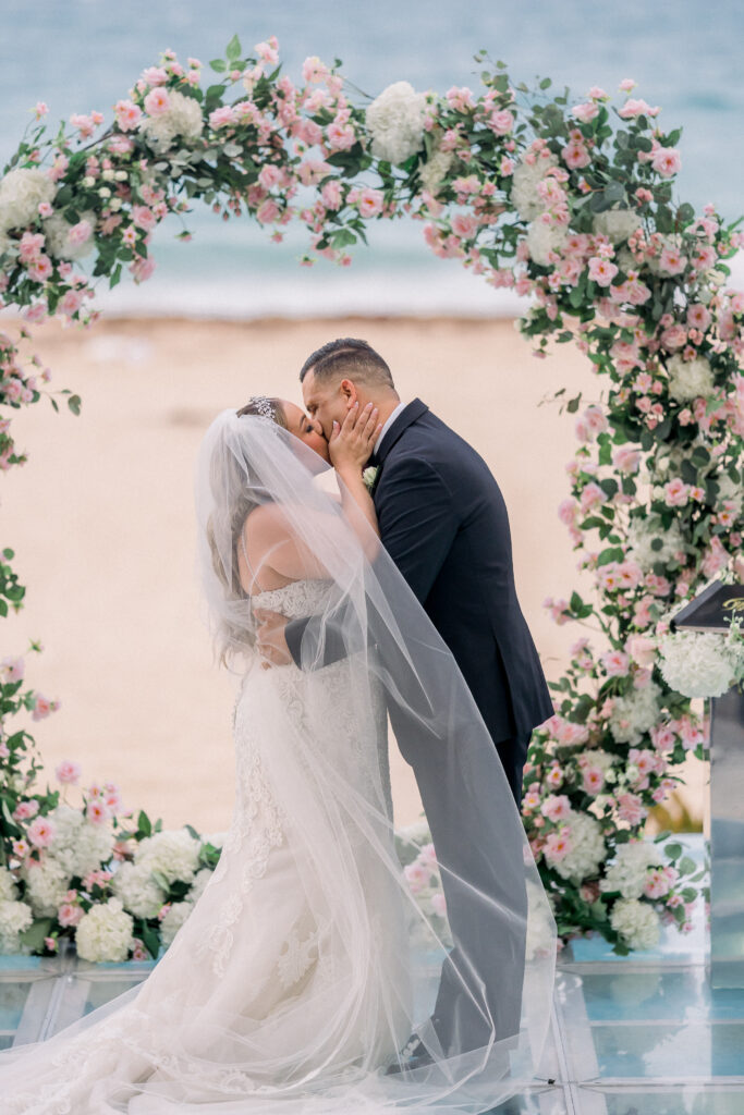 couple kissing at oceanfront wedding at la concha resort