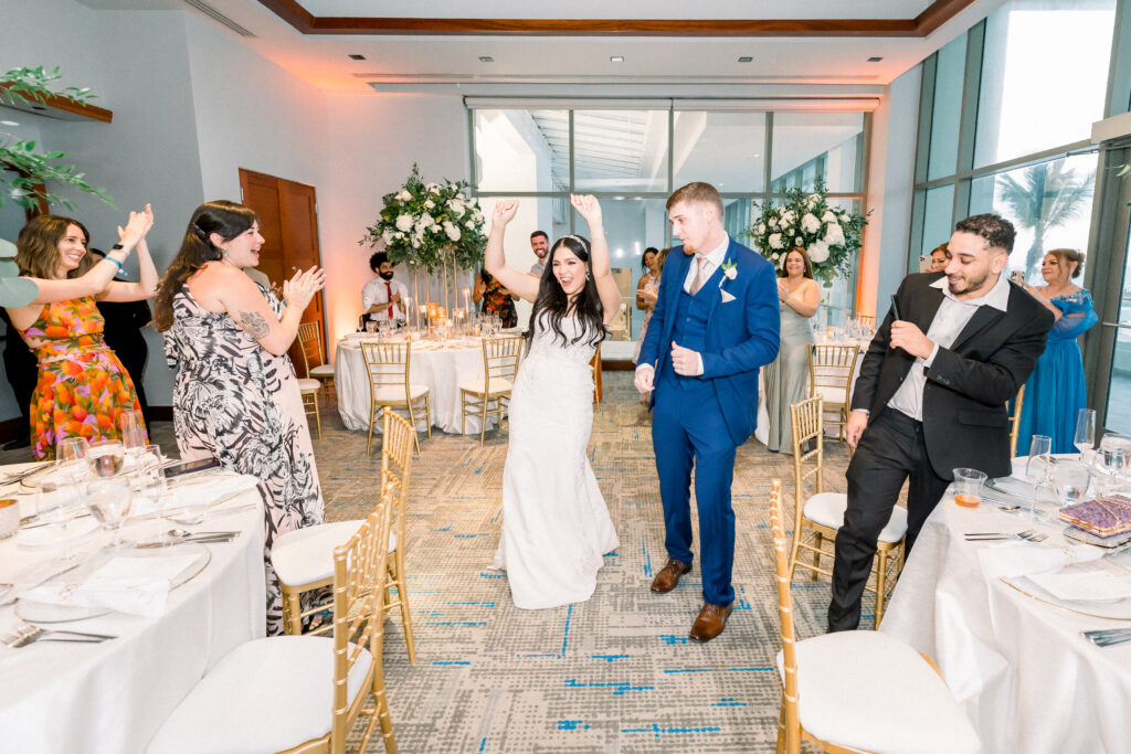 Wedding couple entering their wedding reception while dancing