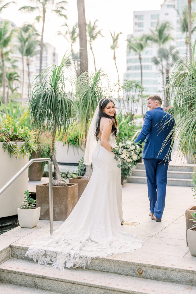 wedding couple at La Concha Resort holding hands and bride looking at camera